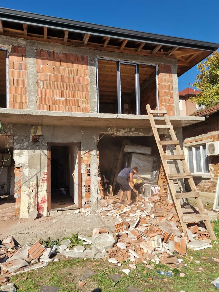 Работник разрушава тухлена стена